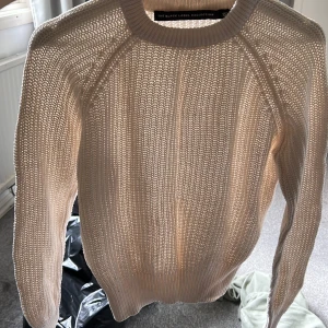 En beige stickad tröja  - Fin på men lite tajt längre ner i armarna, storlek S