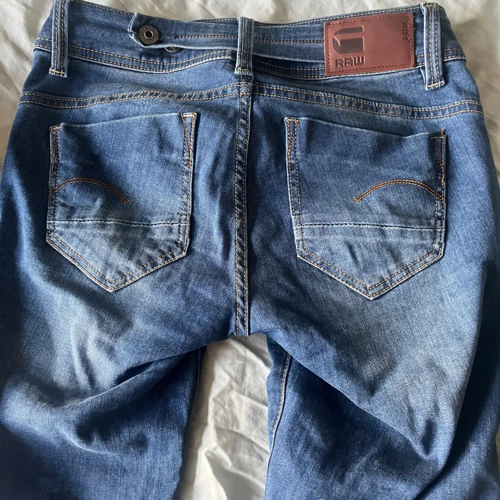 Skit snygga jeans från G-star. Jag har sprättat upp kanten längst ner då de var för korta. På tredje bilden kan man se att de finns ett ”spänne” där bak där man kan spänna åt så att jeansen sitter som man vill😊74 cm i midjan och 79 cm innerbenslängd . Jeans & Byxor.