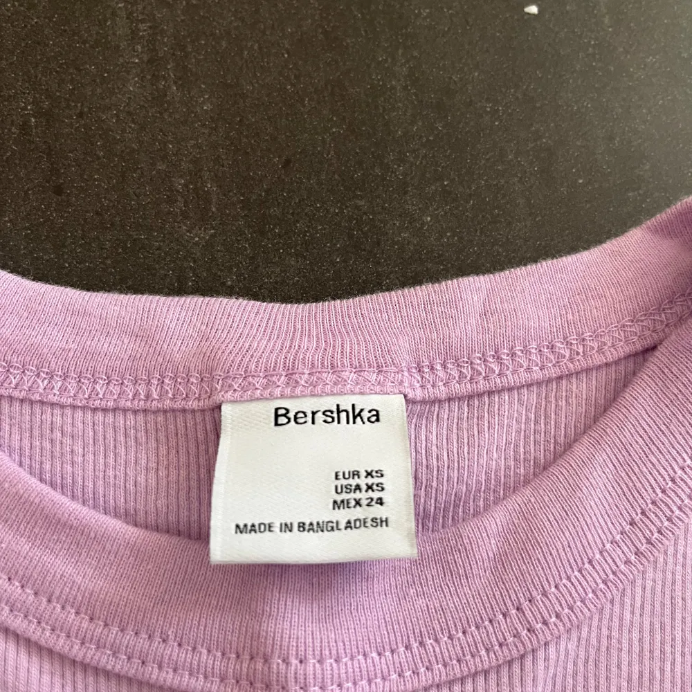 Säljer en söt ljuslila t-shirt från Bershka i storlek XS. Den är ribbad och har korta ärmar, perfekt för sommaren! T-shirten är i bra skick och superbekväm att ha på sig. Passar både till vardags och fest. 🌸. T-shirts.