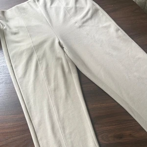 Byxor - Byxor med lite bootcut med en sydd rad mitt på låren