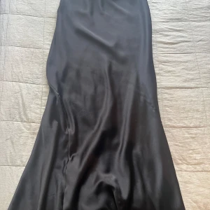 Svart satin kjol - Strl 36, passar även 38 då den är stretchig Helt ny, aldrig använt endast testat och förvarat i garderob! 