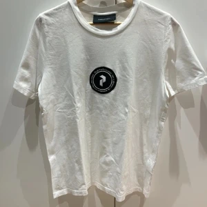 Peak performance T-shirt  - Nu säljer jag min vita peak performance tvist som har ett tryck där bak väldig cool T-shirt💕