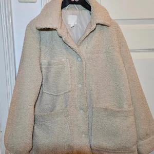 Teddy jacka från hm stl s - Jackan är i fint skick men dock fattas en knapp på ena ärmen. Se bild. Den är naturvit i stl s.