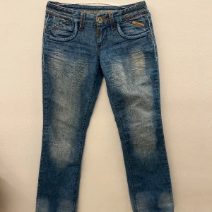 Bootcut low waist jeans - Lågmidjade jeans. Ser inte ut att vara bootcut på bilden då vi har spänt ut midjan med en galge för att ta bilden.  Trendiga och unika.