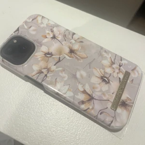 Skal - Mobilskal till iPhone 13 från idealofsweden. Lite slitet. Ljusrosa/beige/vit