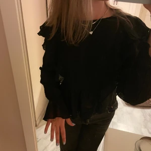 Svart blus  - As snygg svart blus med lite volanger☺️☺️😍använd ett fåtal gånger💕 knappen baktill har tyvärr lossnat men det är inget man ser eller tänker på när man har på sig blusen 🤩