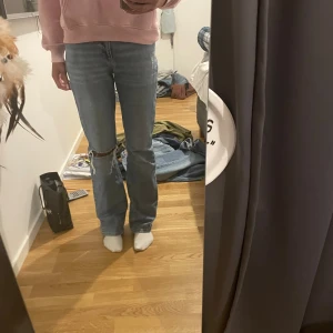 Ljus blåa jeans  - Snugga ljus blåa jeans från Gina med hål på ena benet i storlek 34💞