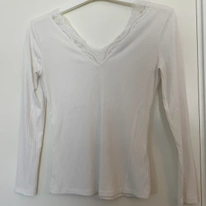 Spets tröja - En tröja med spets i urringningen. Från NA-KD i storlek M