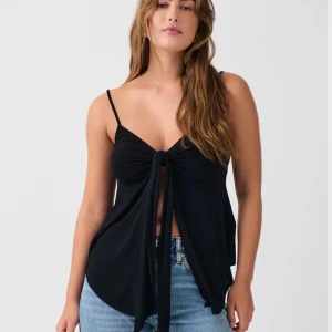 Svart front tie top linne - Svart front tie top från gina tricot. Aldrig använd. Köpte men ångrade köpet pga att jag inte kände mig bekväm i den. Strl xsKom privat för bilder i frågor☺️