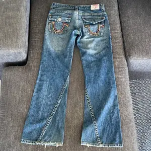 Jättesnygga vintage lågmidjade true religion jeans! Storlek: W30 (passar 36). Innerbenslängd: 82cm, Midjemått 80cm. En knapp saknas på en av bakfickorna. Skriv för fler bilder! (Kan ej visa hur de ser ut på då de är för små för mig)💗 