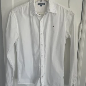 Vit skjorta för barn - Vit skjorta av märket Tommy Hilfiger. Utmärkt skick. Storlek 164