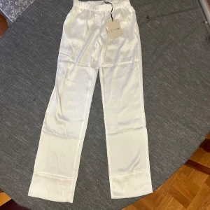 Siden byxor - Säljer dessa snygga låg midjade sidenbyxor från Design by Sí. Aldrig använda och lappen sitter kvar. Var för små för mig och hann inte skicka tillbaka och byta storleken. Super fina nu i sommar!🌸🤩
