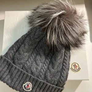 Moncler cashmere vintermössa dam - Köpt i Moncler butik Stockholm city WOOL & CASHMERE BEANIE WITH POM POM kr 3.650,00. Låda tillkommer One size. Ny skick ej använt Varm och elegant till vintrarna. 