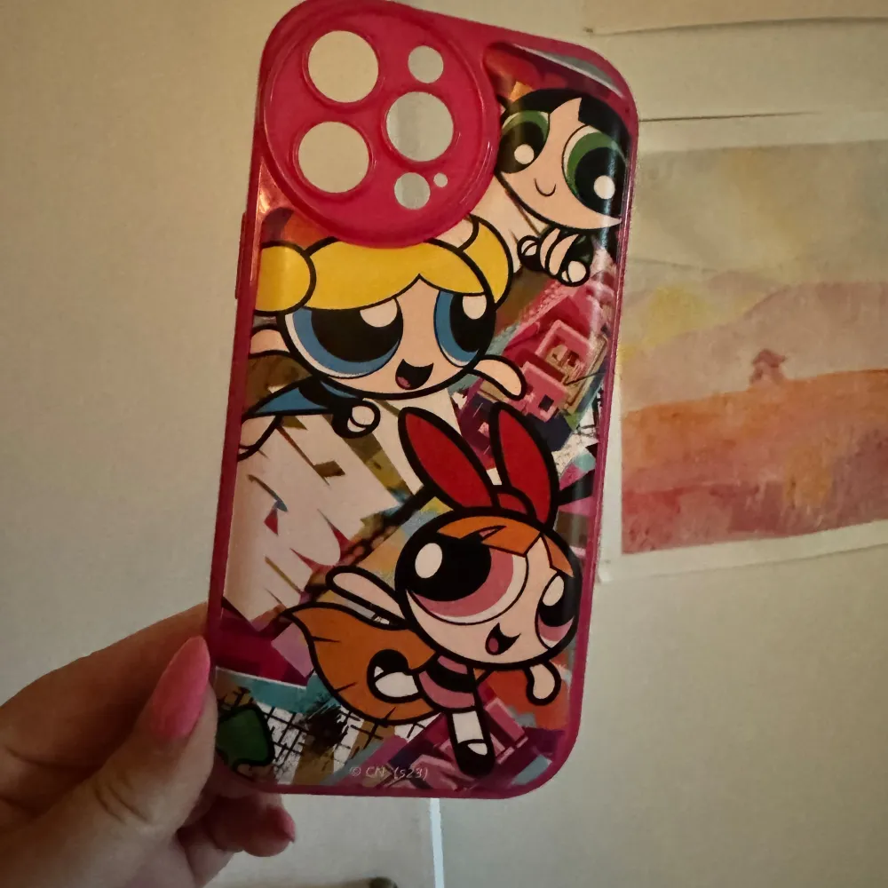 Ett rosa mobilskal med motiv av Powerpuffpinglorna. Skalet har en design med de tre karaktärerna från serien och är gjort av plast. För iPhone 13 PRO Max. Använt en del men bra skick. . Asusteet.