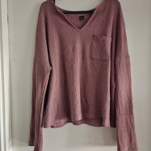 Tröja - Sotig rosa tröja säljes. Stickad med en ficka framtill. Ganska stor i storleken 