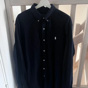 Ralph Lauren skjorta - Säljer en helt oanvänd raffe skjorta pga kommer ej till användning, den är liten i storlek så sitter som XL. Nypris 1599kr mitt pris 499kr Finns ett broderat företag längst ner på ärmen syns knappt!! (Kolla sista bilden)