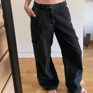 Lågmidjade cargo jeans - Coola baggy jeans med riktigt låg midja i cargomodell. Bra skick! Personen på bilden är 167 cm lång. 