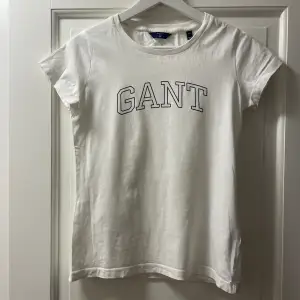 Gant t-shirt. Stilren vit t-shirt med marinblått tryck. 