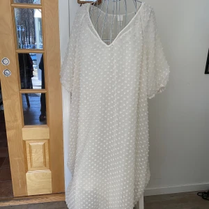 Fantastisk fin Klänning - Ledig modell med underklänning. Klänningen har små knoppar som gör mönstret 