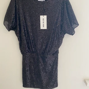 Svart mini paljettklänning - Kort svart paljettklänning från Meet Me There. Helt oanvänd med lappen kvar, passar S.