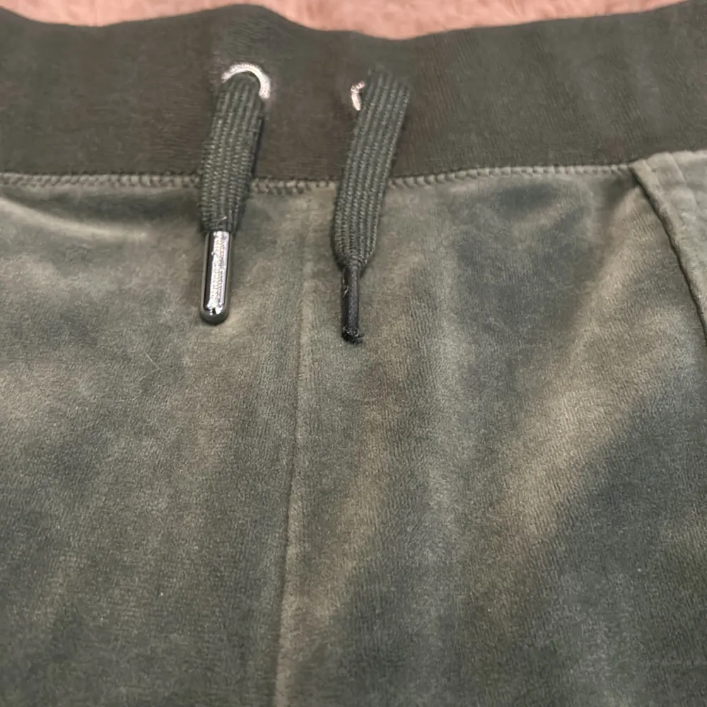 Säljer dessa byxor från Juicy Couture! De är använda men i bra skick. Ena metallbiten på ett av snörena har försvunnit (se sista bilden). Har inte sytt upp, är i original längd. Säljer även en matchande tröja till💚. Jeans & Byxor.