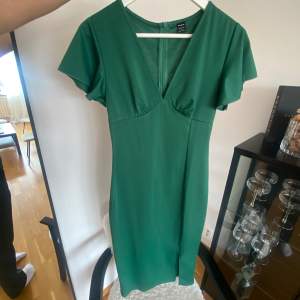 Grön klänning med ”volang” på armen och slits. Supersöt! Säljer åt min mor så har tyvärr ingen bild på.