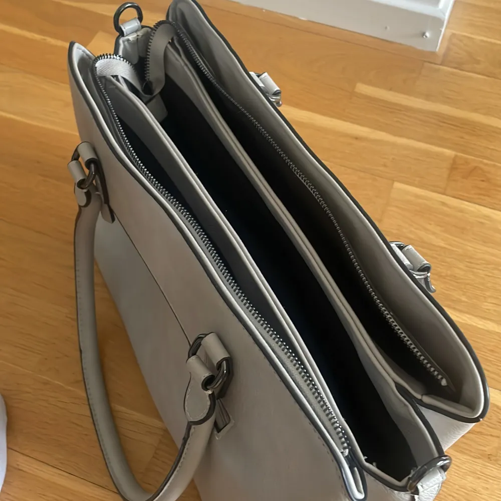 Ljusgrå handväska. Mått: ca 38 x 24  x 13 Finns en längre rem som kan sättas på (som är oanvänd). Fint skick💓. Väskor.