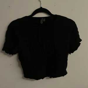 Svart croppad t-shirt från VERO MODA, stl xs - Bra skick, använd bara några gånger. En typ av ribbat tyg, jättefin. Stl xs