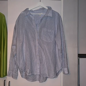 Blå/vit skjorta  - En blå/vit randig skjorta från HM. Säljes då den aldrig är använd. 