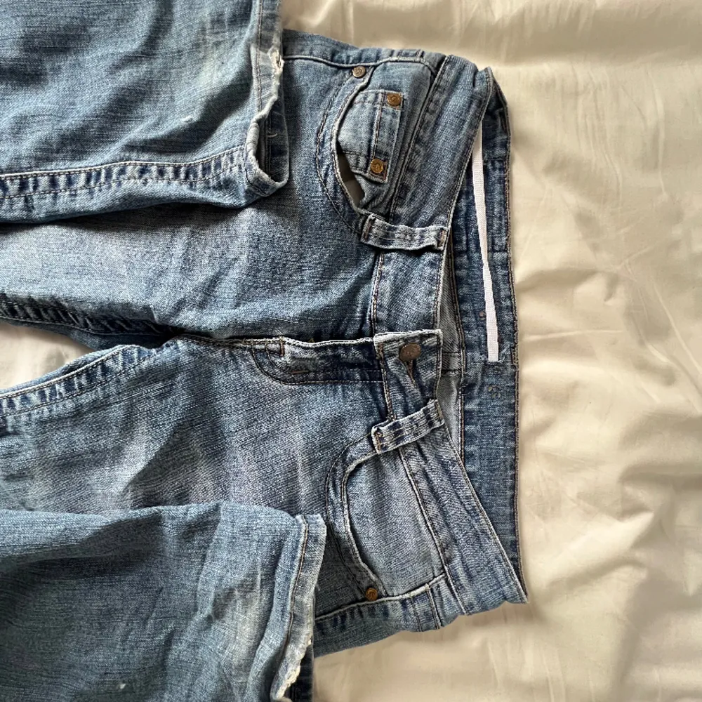 Säljer blåa jeans, köpts på second hand. De är i utsvänga/vida och lågmidjade. De har inga defekter men har insytt band vid midjan (se bild 3)❤️ Kontakta för bilder eller frågor🩷. Jeans & Byxor.