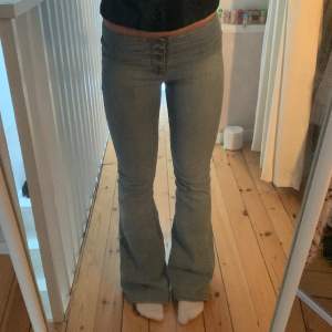 Säljer dessa sjukt snygga jeans med knappar! Nästan aldrig andvända. Midjemått rakt över är ungefär 35 cm och Innerbenslängd ungefär 80 cm.💕💕