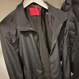 Hugo Boss jacka - Riktigt snygg Hugo Boss jacka, nypris 3300 aldrig använd pga att den var för liten för mig. Storlek L passar egentligen allt från M-XL, XL har jag men den börjar bli för liten. Kontakta mig! Pris kan diskuteras vid snabb affär.