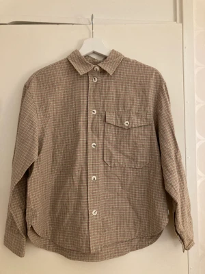 Rutig skjorta Wood Wood - Långärmad, rutig skjorta från Wood Wood i rosa och ljusgrönt. Tillverkad av bomull. storlek 36. färgarna syns bäst på sista bilden