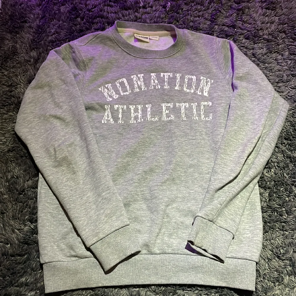 Sweatshirt från märket ”Nonation athletic” i färgen grå och ett tryck av märket ”Nonation athletic” i färgen vit. Inget slitage och inget tecken på användning.. Tröjor & Koftor.