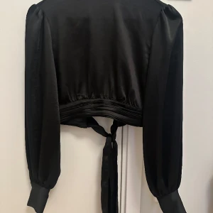 NA-KD blus - En snygg svart blus från NAKED med öppen rygg och knyttning vid ryggen. Använd endast en gång