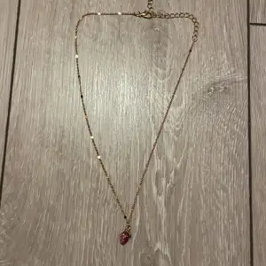 Säljer en fin guldig halsband med en lila jordgubb | fick den som present | aldrig använt 
