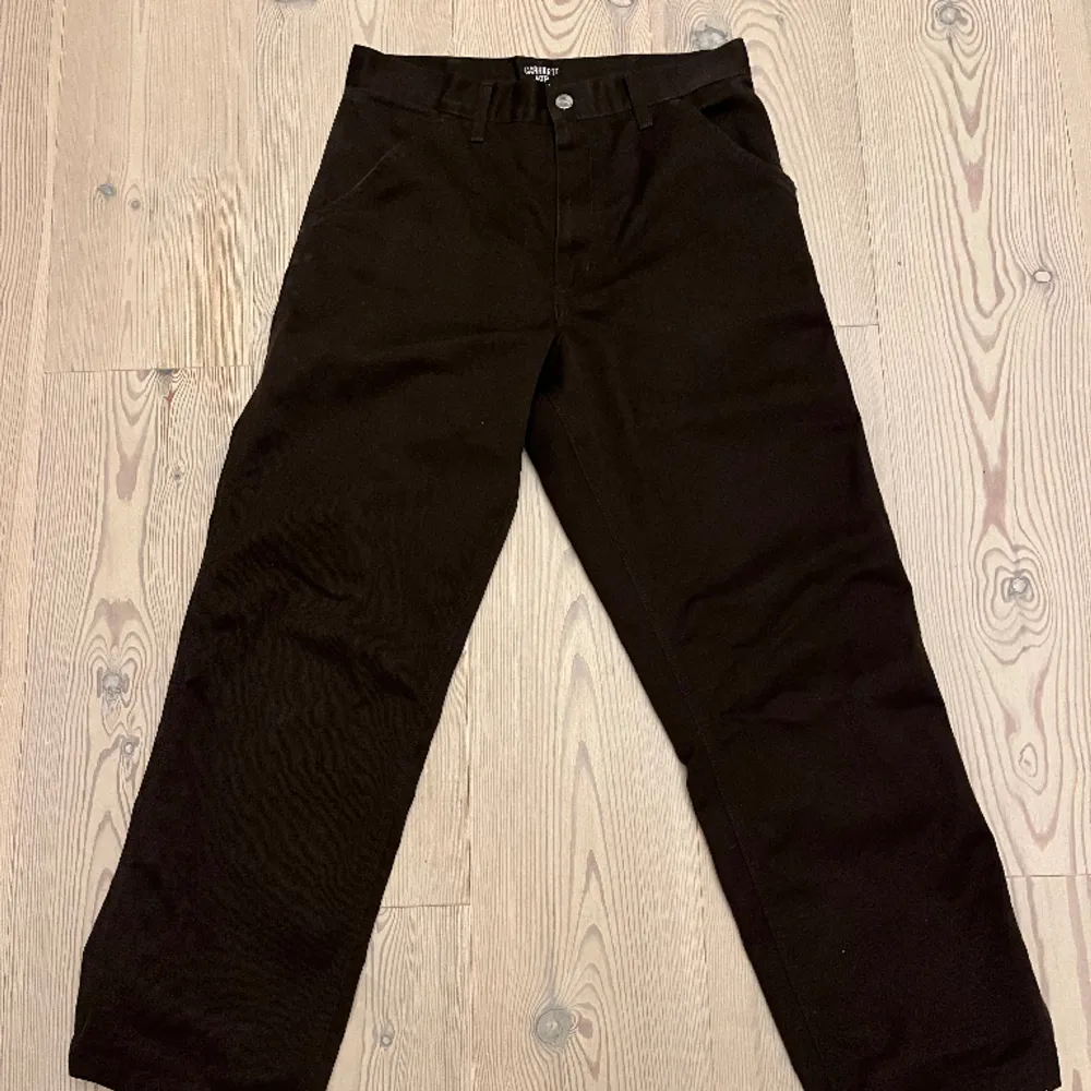 Ett par mörkbruna carhartt simple pant i storlek 28/32, helt okej skick. . Jeans & Byxor.