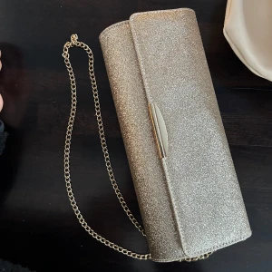 Jättefin kuvertväska - Världens finaste kuvertväska från Anna Field, hade denna på balen och var perfekt. Den är rymlig men inte klumpig. Den är i en champangeaktig färg med glitter. Finns en fläck inuti väskan som jag självklart tvättar bort innan leverans💞 pris kan diskuteras