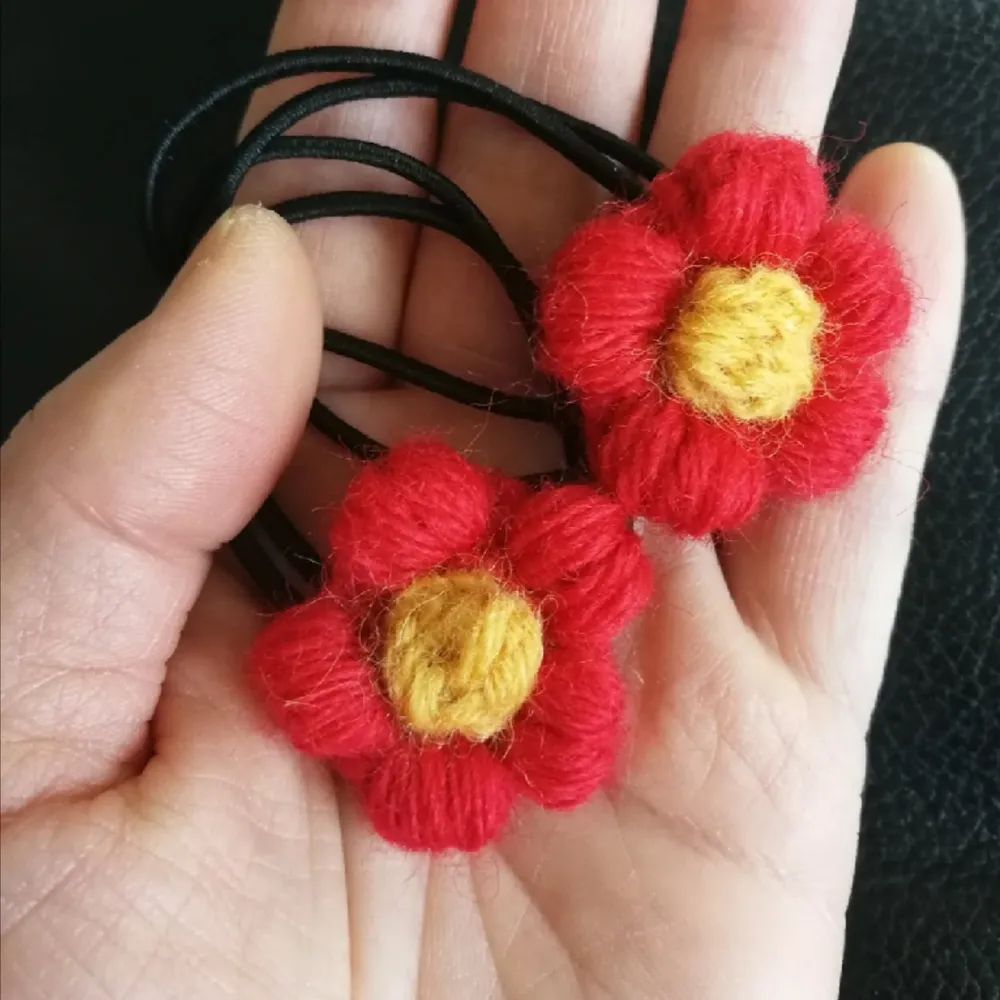 Unik handvirkad. 2 st hårsnoddar med röda blomman. Svart Gummiband är ca 4 cm i diameter. . Accessoarer.