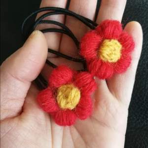 Unik handvirkad. 2 st hårsnoddar med röda blomman. Svart Gummiband är ca 4 cm i diameter. 