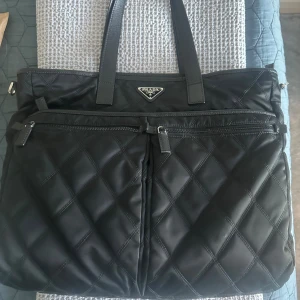 Prada datorväska  - Säljer denna Prada datorväskan. Som är perfekt  till vardags. Den är i nyskick och använd ca 2 gånger. Den är självklart äkta, köpt i Prada butiken i Stockholm. 