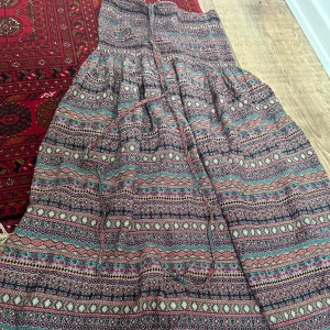 Kjol/klänning  - Tror det är en kjol går väl använda som en klänning med om man hade velat.  Jättefint mönster på den.  Skriv för fler bilder.   Man kan ha den som en lågmidjad kjol jag är 160 cm och har jag den lågmidjat når den precis till marken. 