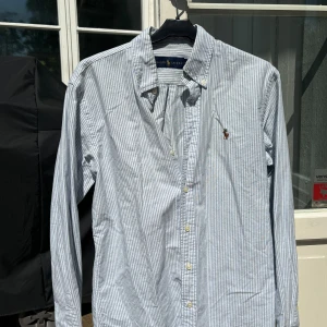 Ralph Lauren Oxford Skjorta - blåvit randig  - Ralph Lauren skjorta i mycket bra skick, storlek S. Säljer pga vuxit ur den. Passar dig som är 170-180