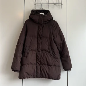 Dunjacka - Vinterjacka i mycket bra skick! 90% dun, 10% fjäder. Köpt förra vintern, men säljer pga ska bort denna vinter. Mörkbrun, är lite Oversize i storleken. 