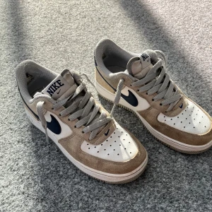 Air Force 1  - Jätte fina Air Force 1s som är i strl 36, de har två ”hål” bak i skorna/ hälen och lite slitna bak under sulan! Är i väldigt bra skick. Det beiga är i mocka resten är i skin. Nypris ca 1500kr! Skicka vid intresse!