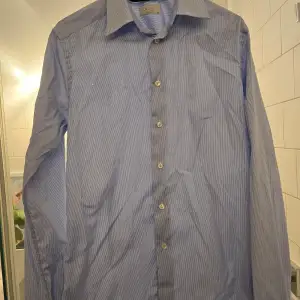 Snygg skjorta i bästa kvalitén från Eton. Tyvärr ett hål i fram enligt bild så med andra ord perfekt under en tröja.  Storlek 39 Super Slim