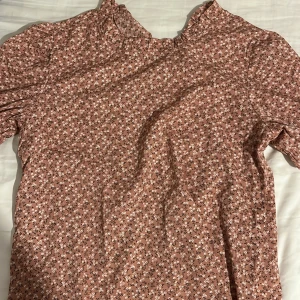 Blus - Fin rosa/brun/beige blus med blommor på. Perfekt till sommaren. Använd en gång och är i storlek XS.