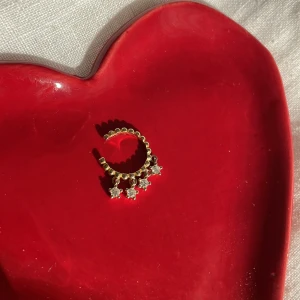 Guldplätterad earcuff - Earcuff i äkta silver med guldplättering. Alla stenar på plats. Mycket fint skick. Köpt i en butik i Portugal, minns tyvärr inte namnet på butiken/märket. Går att justera till örats storlek.