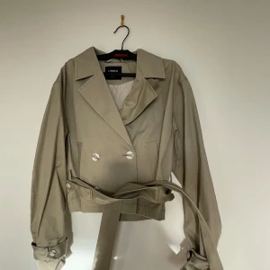 Trenchcoat cropped - Croppad trenchcoat från Lindex i storlek XS men passar även S. Nypris 999. Endast använd ett fåtal gånger.