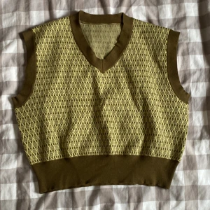 Finstickad väst - En finstickad väst i grönt. Så gott som oanvänd.